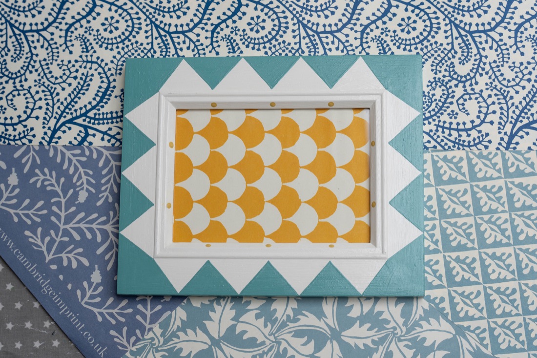 A picture frame painted with blue and white triangles.