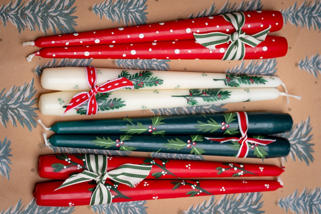 Red, green and cream candles with hand-painted festive details and ribbons.