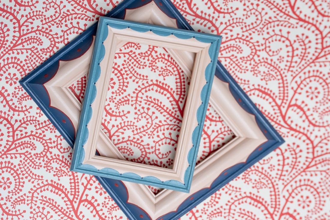 Layered blue and pink hand-painted picture frames on patterned paper.